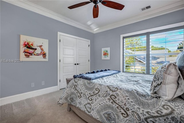 bedroom with crown molding, light carpet, ceiling fan, and a closet