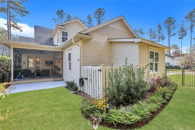 rear view of house featuring a sunroom, a yard, and ceiling fan