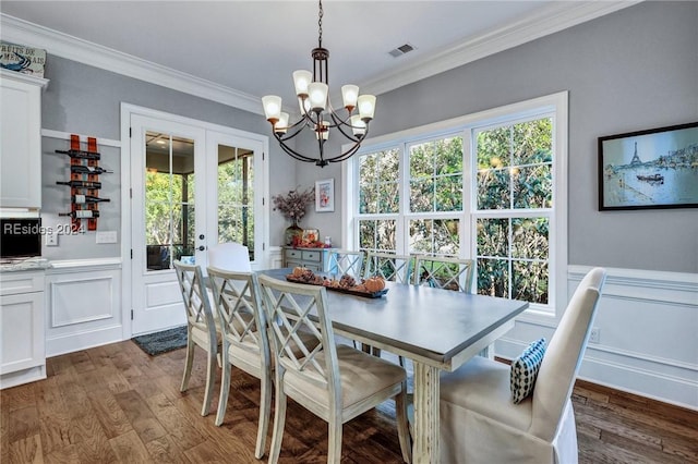 dining space featuring ornamental molding, dark hardwood / wood-style floors, a chandelier, and french doors