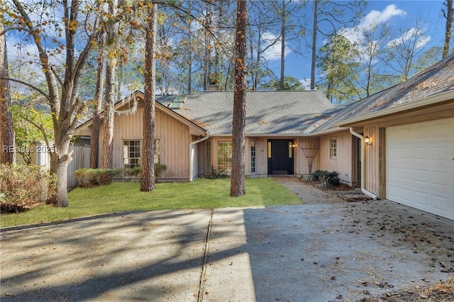 ranch-style house featuring a garage and a front lawn