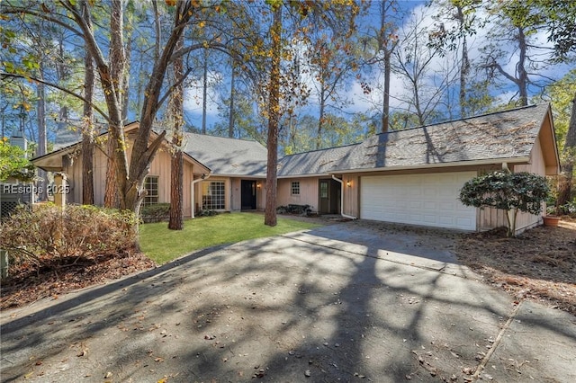 ranch-style home featuring a garage and a front lawn