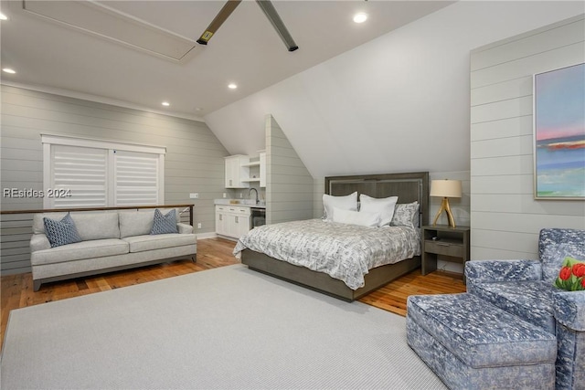 bedroom with ceiling fan, wood-type flooring, wood walls, and lofted ceiling