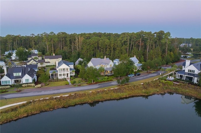 aerial view at dusk featuring a water view