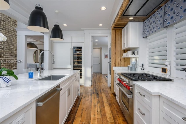 kitchen featuring sink, hanging light fixtures, stainless steel appliances, white cabinets, and dark hardwood / wood-style flooring