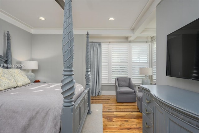 bedroom featuring ornamental molding, beam ceiling, and light hardwood / wood-style flooring