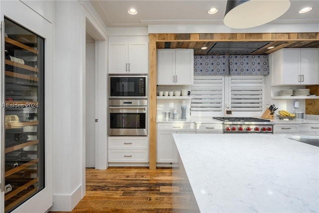 kitchen with wine cooler, dark wood-type flooring, light stone counters, appliances with stainless steel finishes, and white cabinets