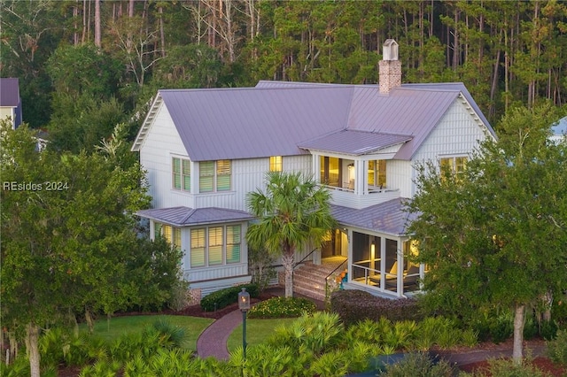 view of front of house featuring a front lawn, a balcony, and covered porch