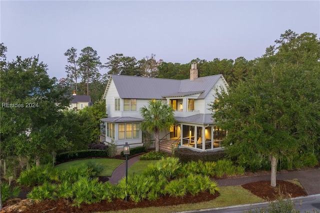 view of front facade with a sunroom and a front yard