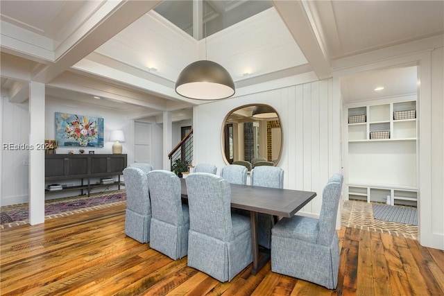 dining space featuring hardwood / wood-style floors and beamed ceiling