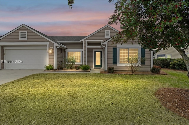 view of front of home with a garage and a yard