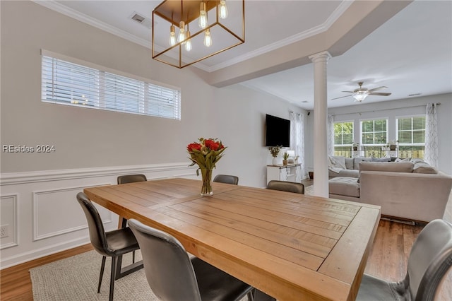 dining room featuring crown molding, ceiling fan, wood-type flooring, and decorative columns