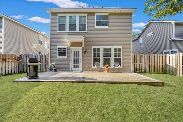 rear view of house with a wooden deck and a yard