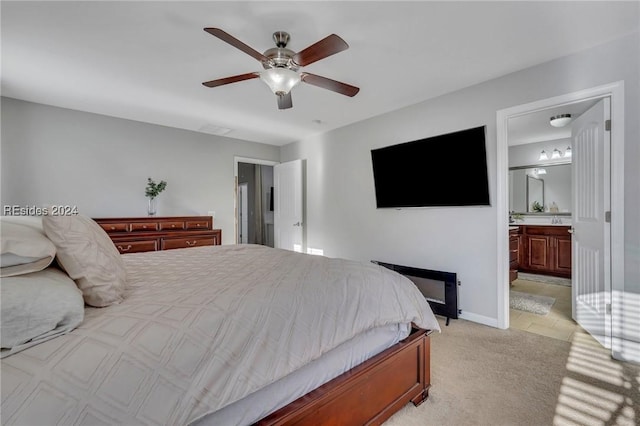 bedroom with light carpet, connected bathroom, and ceiling fan