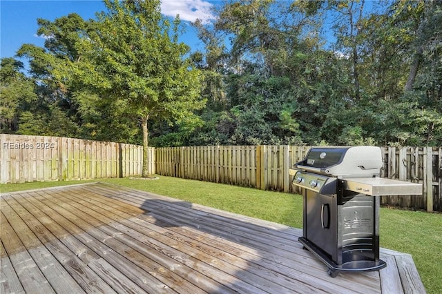 wooden terrace featuring grilling area and a yard