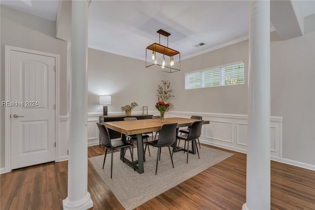 dining space featuring crown molding, dark hardwood / wood-style flooring, and decorative columns