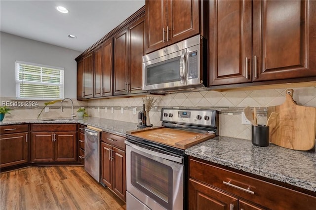 kitchen with light stone counters, sink, and stainless steel appliances