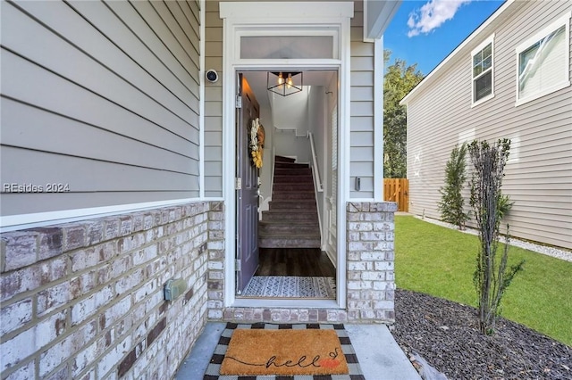 view of exterior entry with a lawn