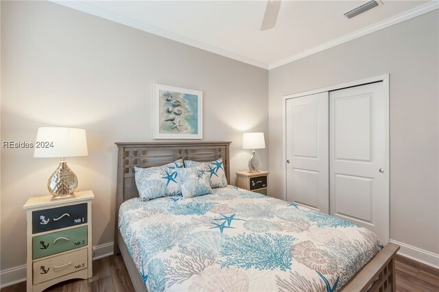 bedroom with dark wood-type flooring, ornamental molding, a closet, and ceiling fan