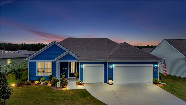 view of front facade with a garage and a lawn