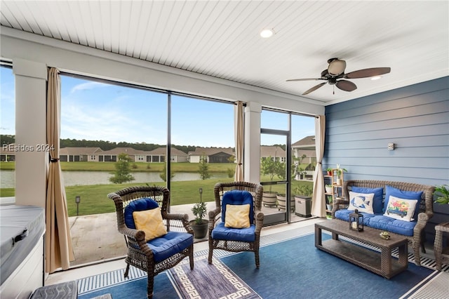 sunroom featuring a water view and ceiling fan