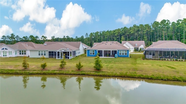 rear view of house featuring a lawn and a water view