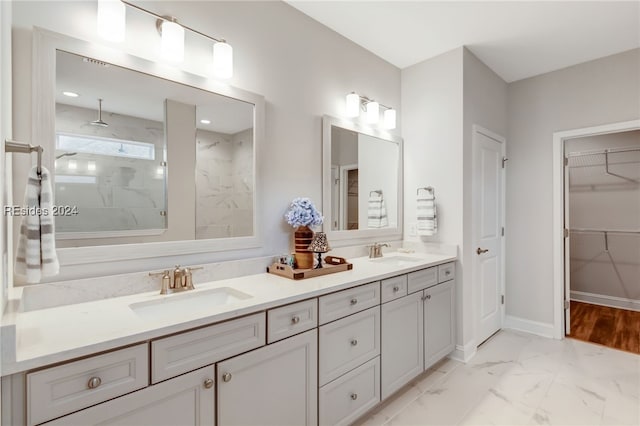 bathroom with a tile shower and vanity