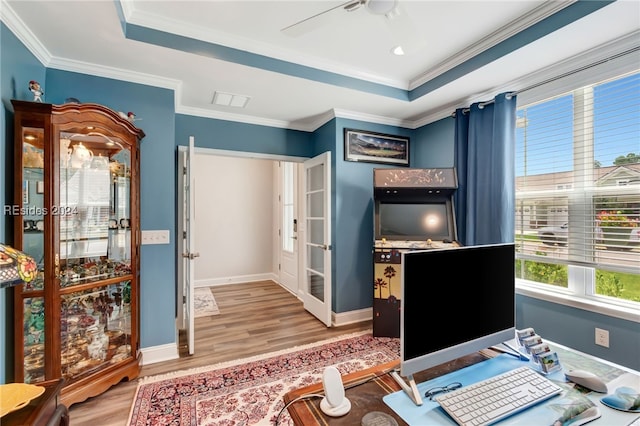 office featuring crown molding, a tray ceiling, ceiling fan, and hardwood / wood-style flooring