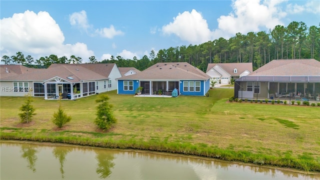 back of house featuring a water view, a lanai, a yard, and a sunroom