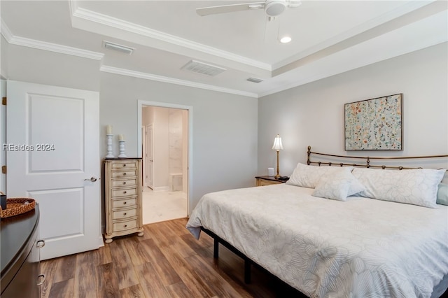 bedroom featuring hardwood / wood-style flooring, ceiling fan, ornamental molding, and ensuite bath