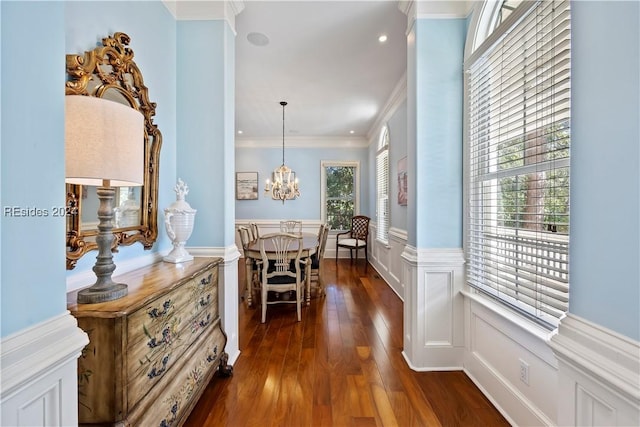 corridor featuring ornamental molding, an inviting chandelier, and dark hardwood / wood-style flooring