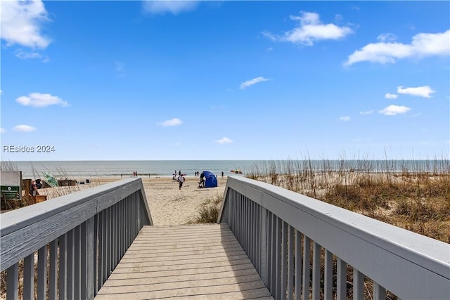 view of home's community featuring a water view and a beach view