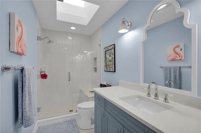 bathroom featuring tile patterned flooring, a skylight, vanity, a shower with shower door, and toilet