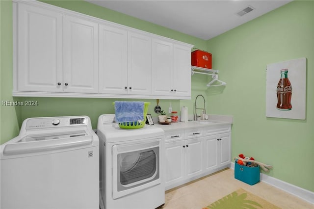 laundry room featuring light tile patterned flooring, cabinets, separate washer and dryer, and sink