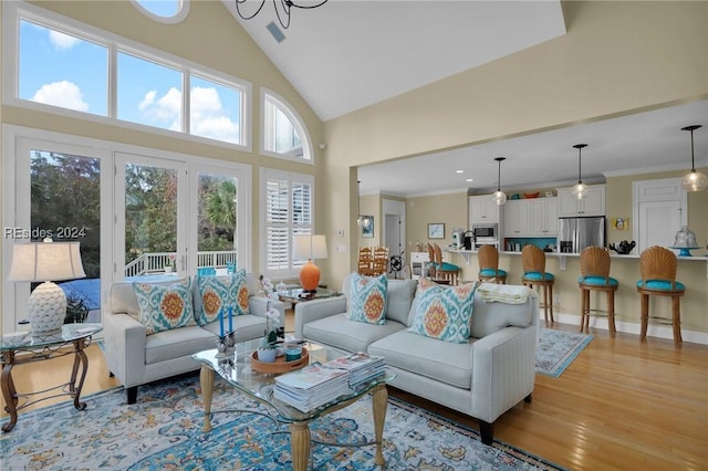 living room with ornamental molding, high vaulted ceiling, and light hardwood / wood-style floors