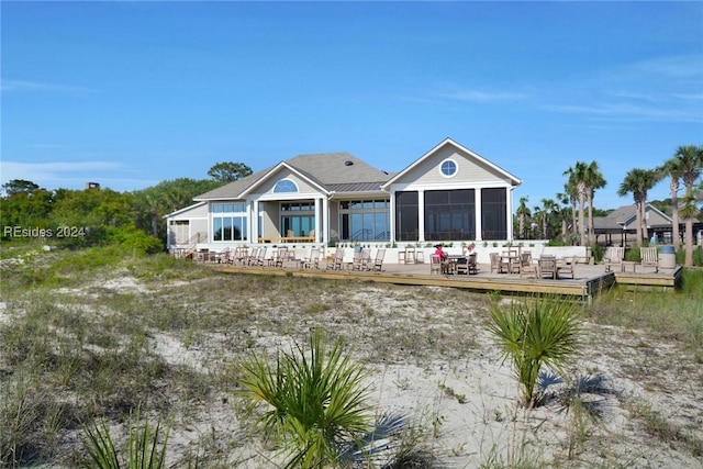 back of property featuring a wooden deck and a sunroom