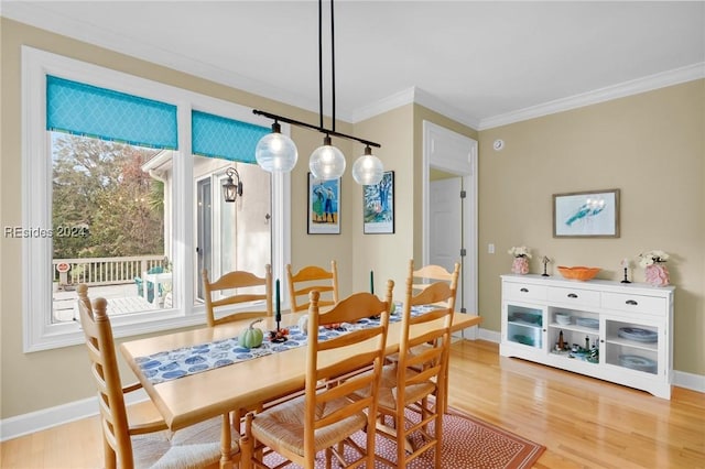 dining area with hardwood / wood-style flooring and ornamental molding