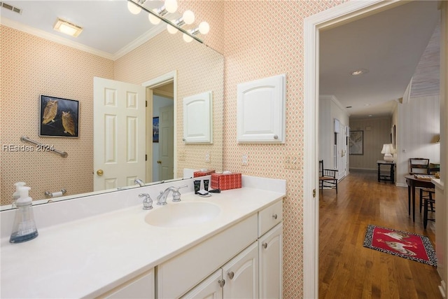 bathroom with crown molding, vanity, and hardwood / wood-style floors