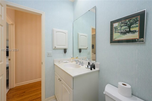 bathroom with hardwood / wood-style flooring, vanity, and toilet