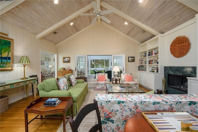 living room with wood ceiling, a fireplace, built in features, and light wood-type flooring