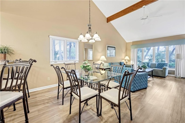 dining area featuring beamed ceiling, high vaulted ceiling, ceiling fan with notable chandelier, and light hardwood / wood-style floors