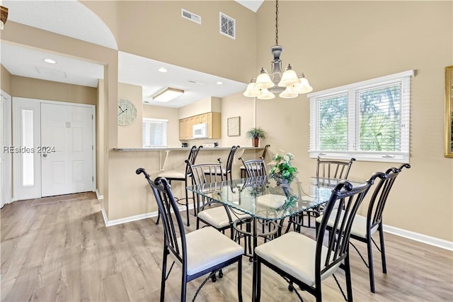 dining area with a chandelier and light hardwood / wood-style flooring