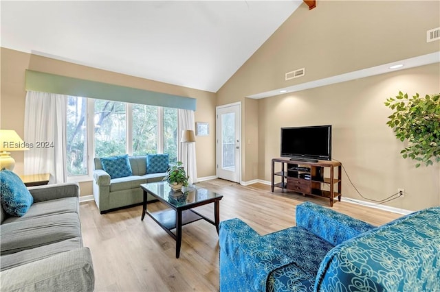 living room featuring beamed ceiling, high vaulted ceiling, and light wood-type flooring