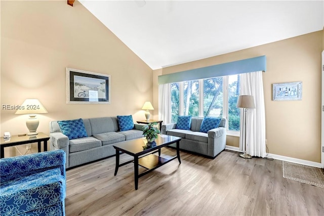 living room with high vaulted ceiling and hardwood / wood-style floors