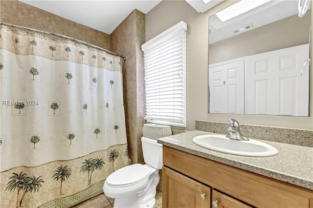 bathroom with tile patterned floors, toilet, curtained shower, and vanity