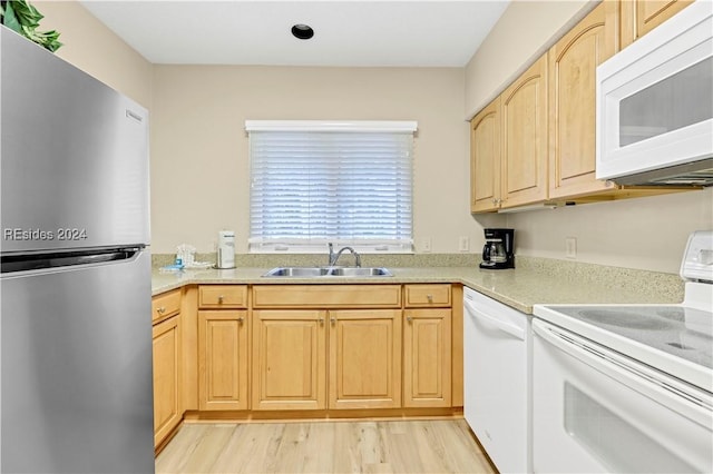 kitchen featuring light brown cabinetry, sink, white appliances, and light wood-type flooring