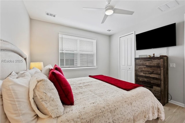 bedroom with hardwood / wood-style flooring, ceiling fan, and a closet