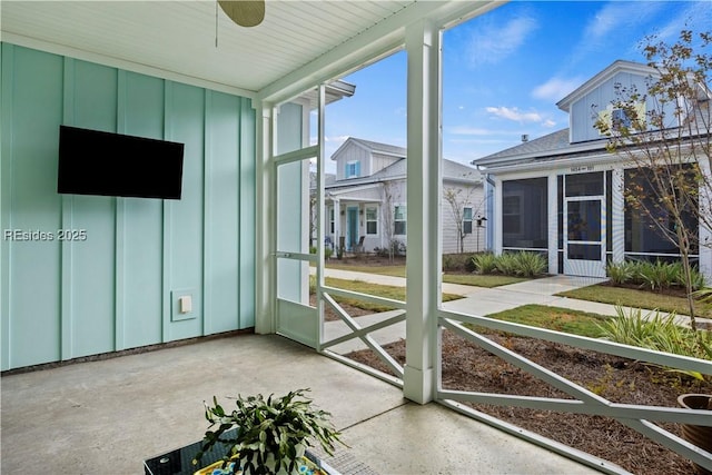 unfurnished sunroom featuring ceiling fan