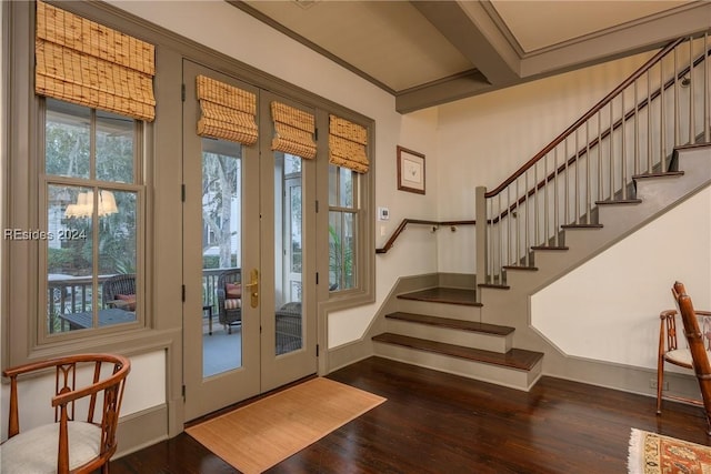 doorway to outside with beam ceiling, crown molding, and dark wood-type flooring