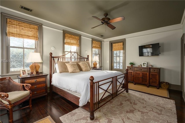 bedroom with crown molding, ceiling fan, dark hardwood / wood-style flooring, and multiple windows