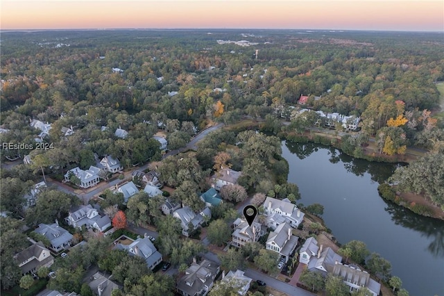 aerial view at dusk featuring a water view